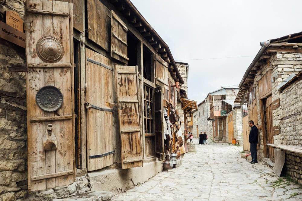 An old street in Lahic, with cobbles underfoot and rows of shops with heavy wooden shutters.