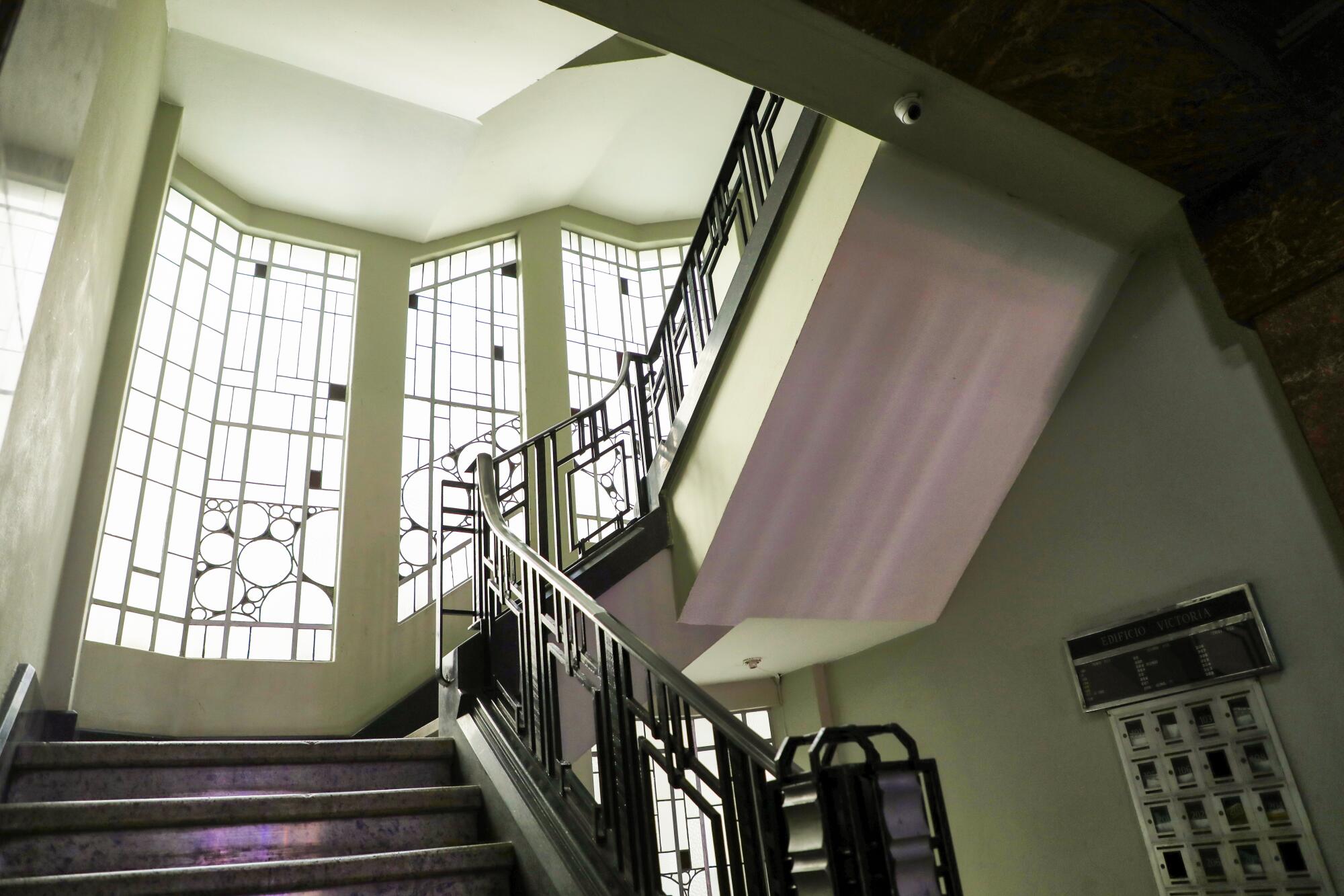 An ornate stairwell and windows in an old building in Mexico City.