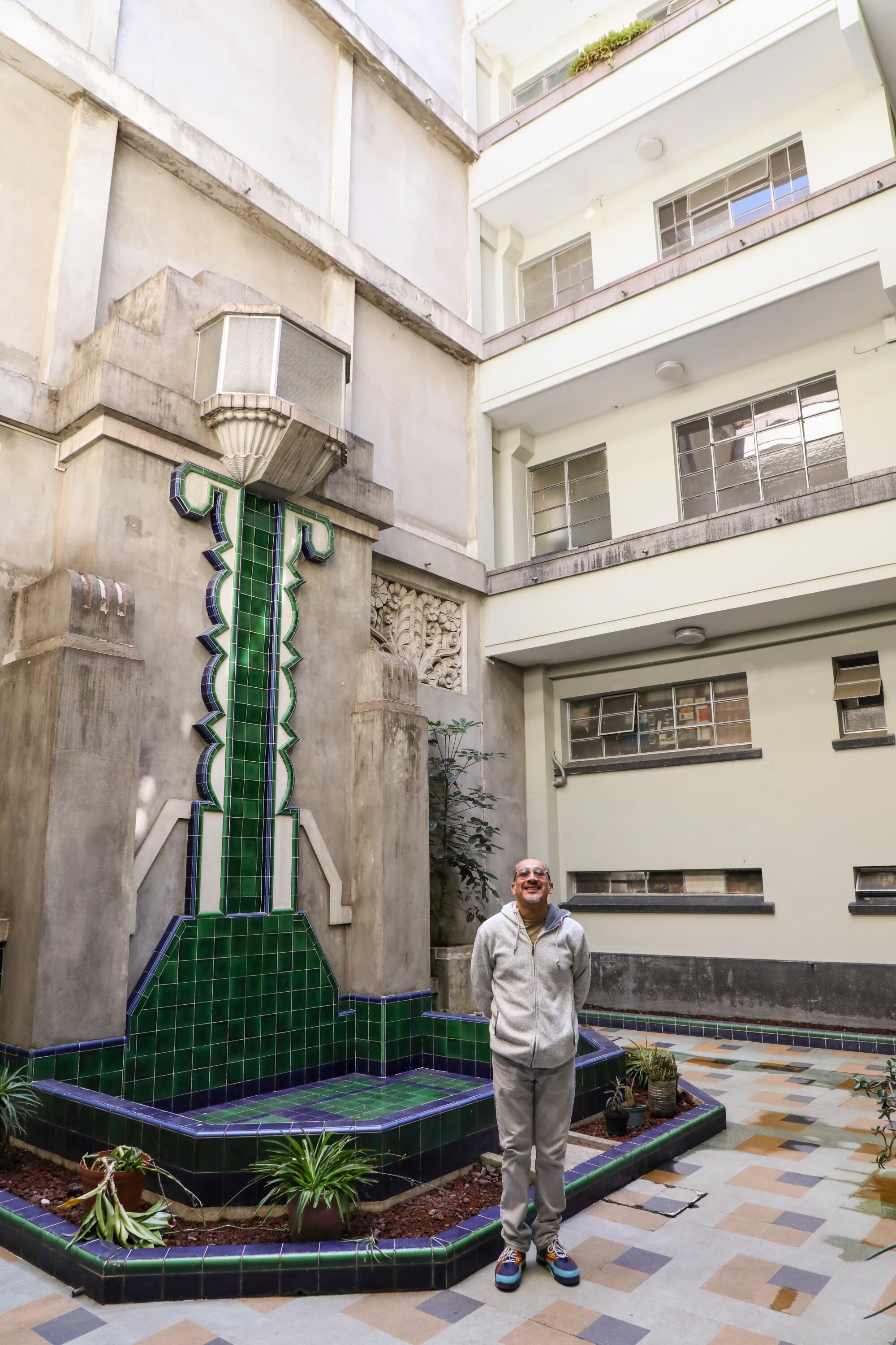 A man stands in the ornate outdoor area of a vintage building.