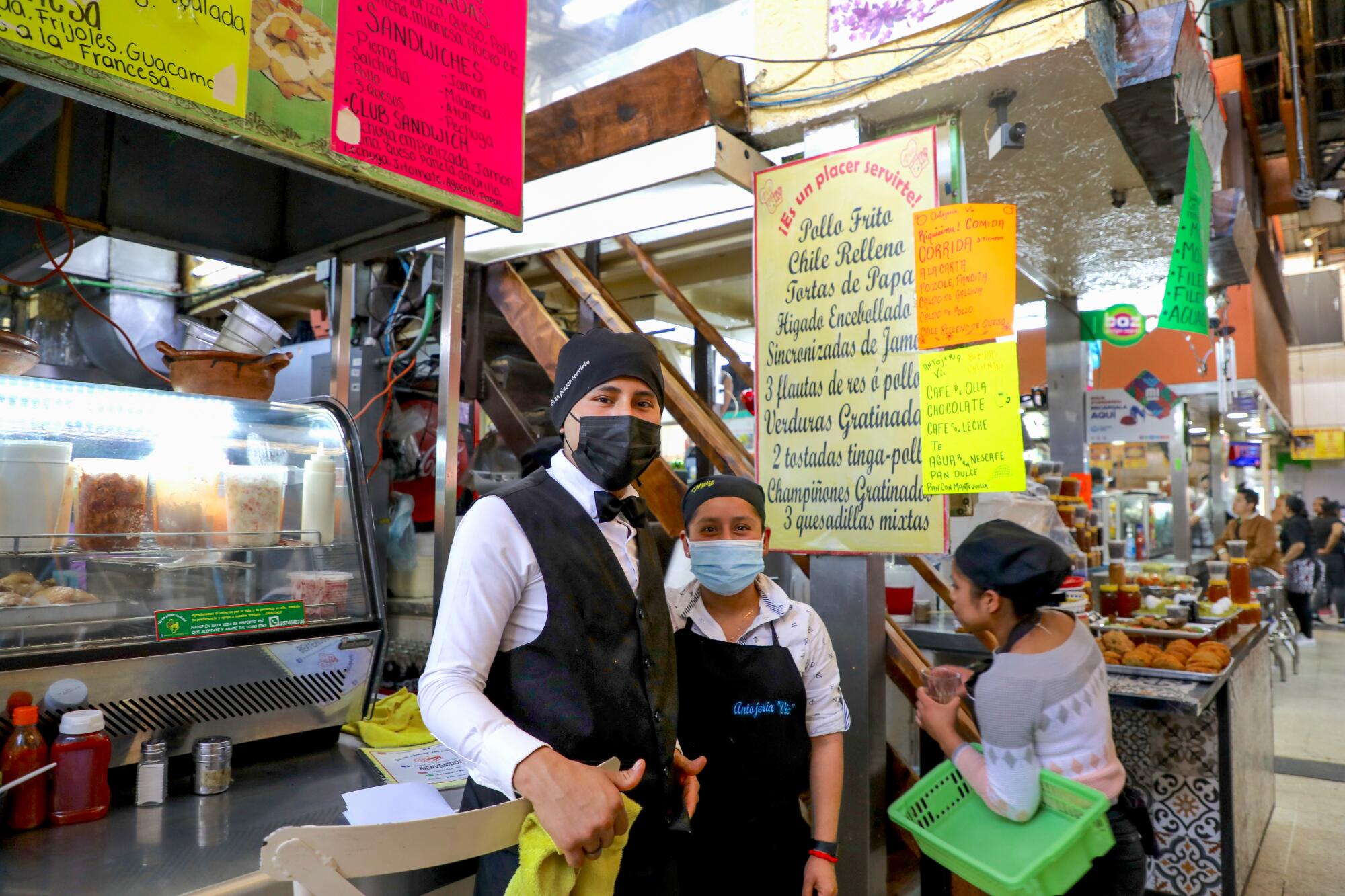 A server and a cook at a fonda stall inside the Mercado San Juan Arcos de Belén in Mexico City.