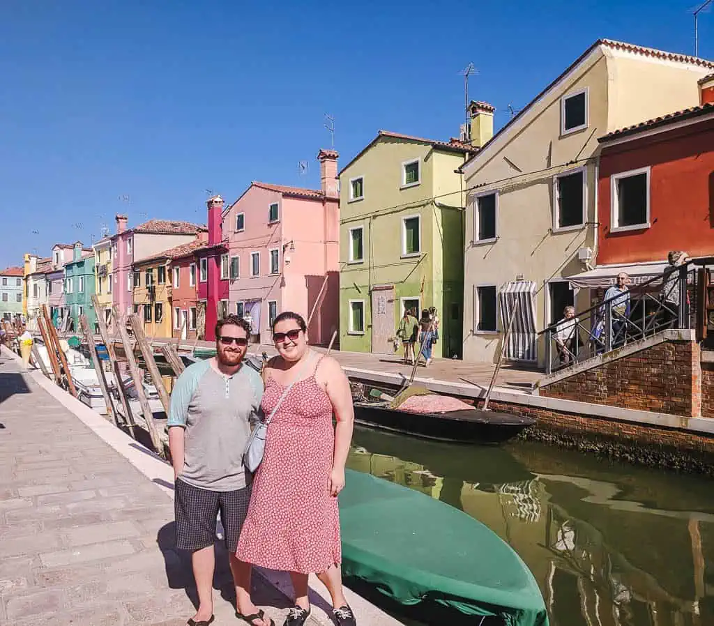 Riana and Colin posing along the canal and colourful houses of Burano, outside of Venice