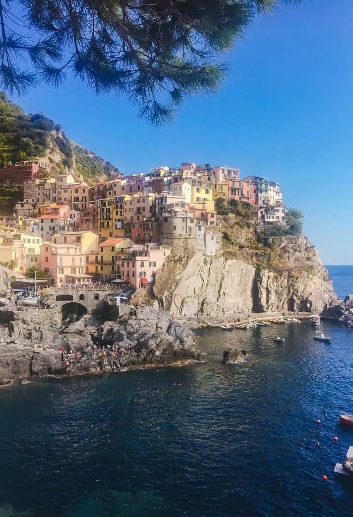 View of the houses on the cliff and water down below in Manarola, Cinque Terre, Italy