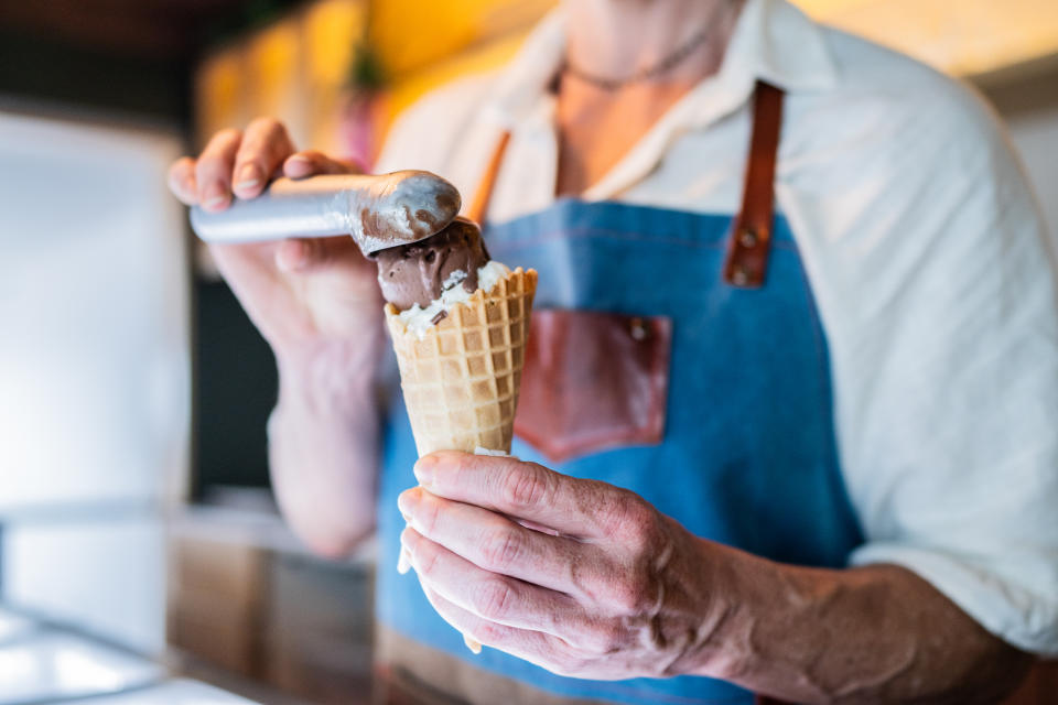 Close-up of a ice cream seller preparing ice cream at ice cream shop