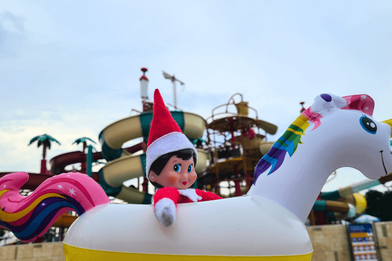 An elf on the shelf inside an inflatable pool toy in front of aqua Park nessebar.