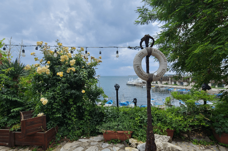 A picturesque street in Nessebar with little string lights overlooking the sea.