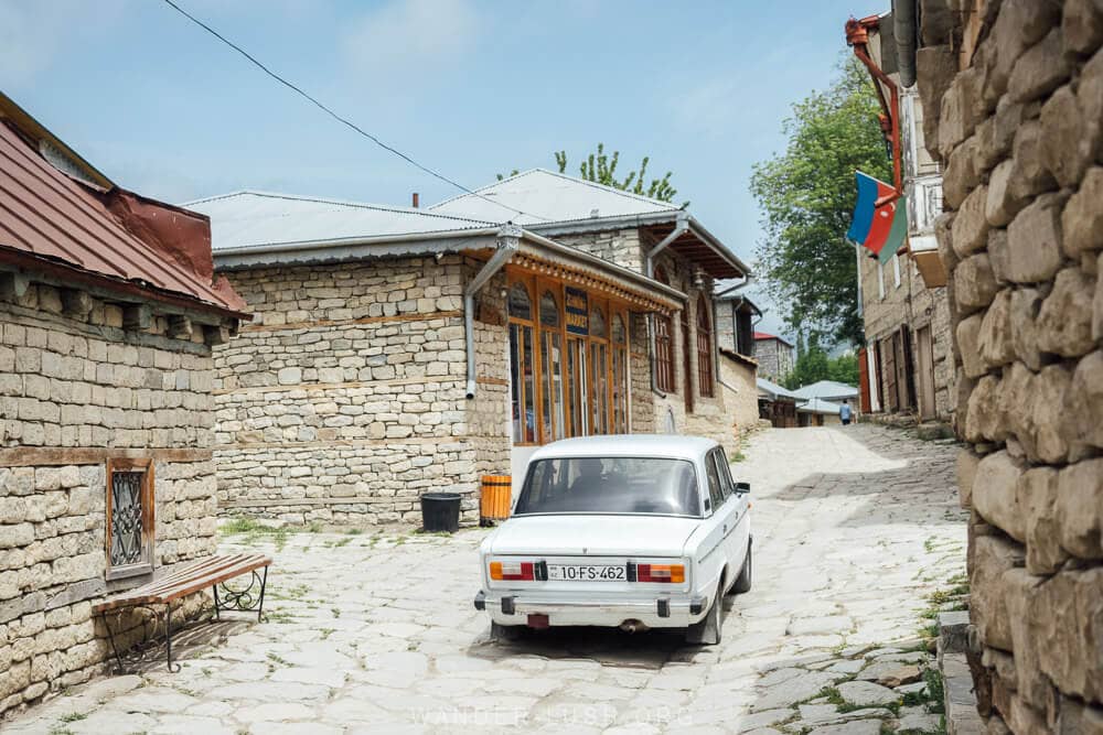 A white Lada car on a cobbled street in Lahic, Azerbaijan.