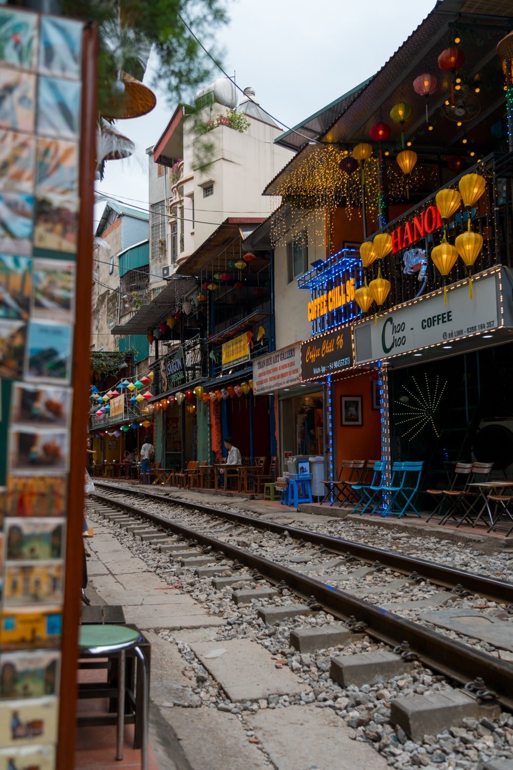 Cafes and shops selling food and souvenirs on Hanoi's famous train street in Vietnam.