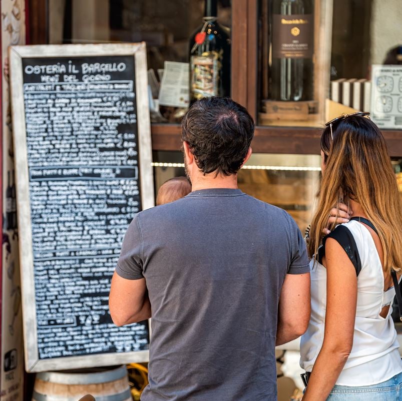 Couple looking at outdoor menu that is not in english