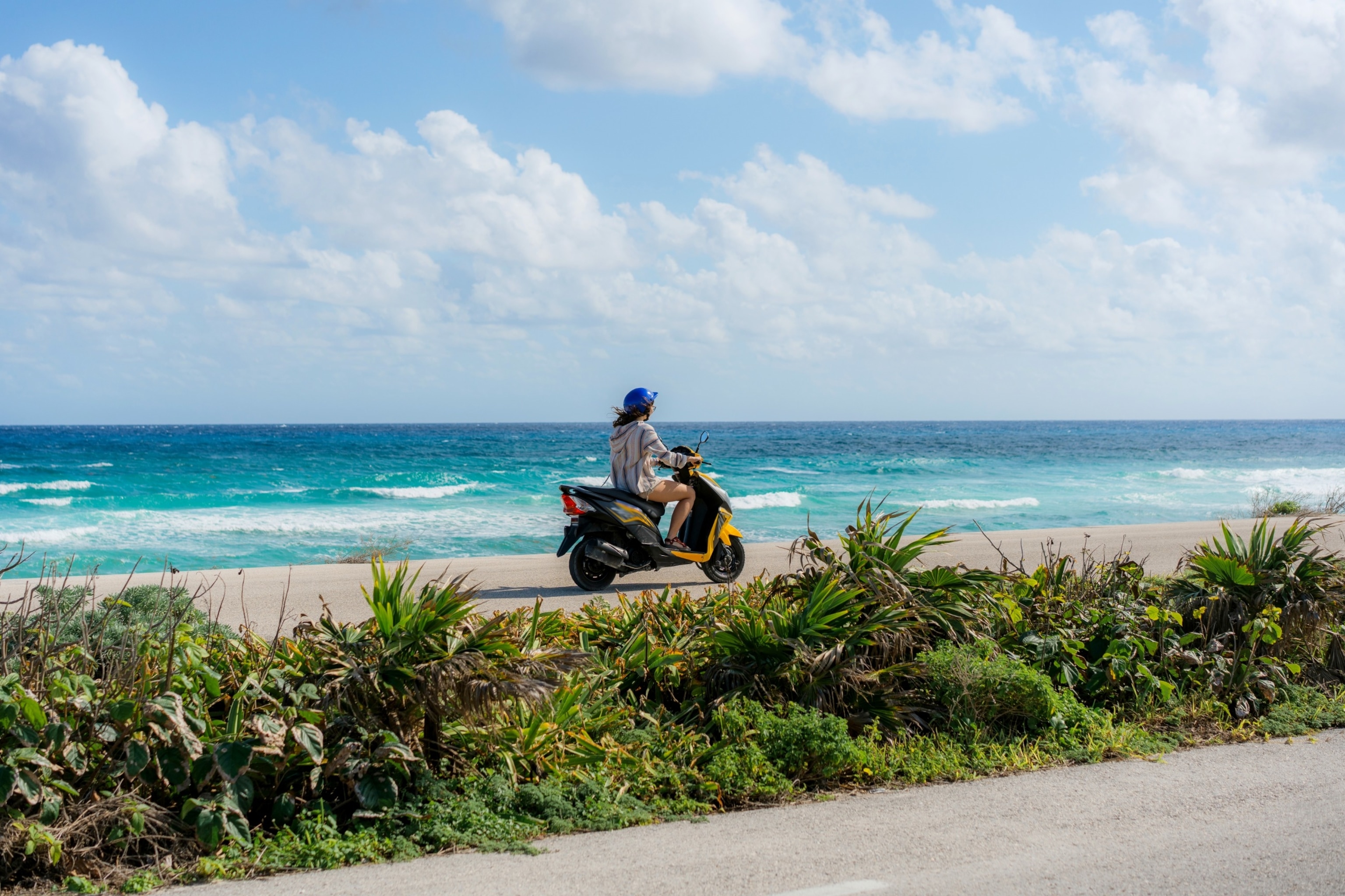 PHOTO: Young woman driving a scooter on Cozumel Island.