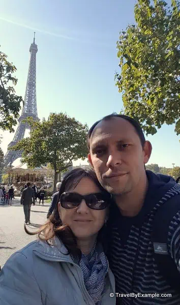 Elena and her husband taking a selfie in front of the Eiffel Tower in Paris