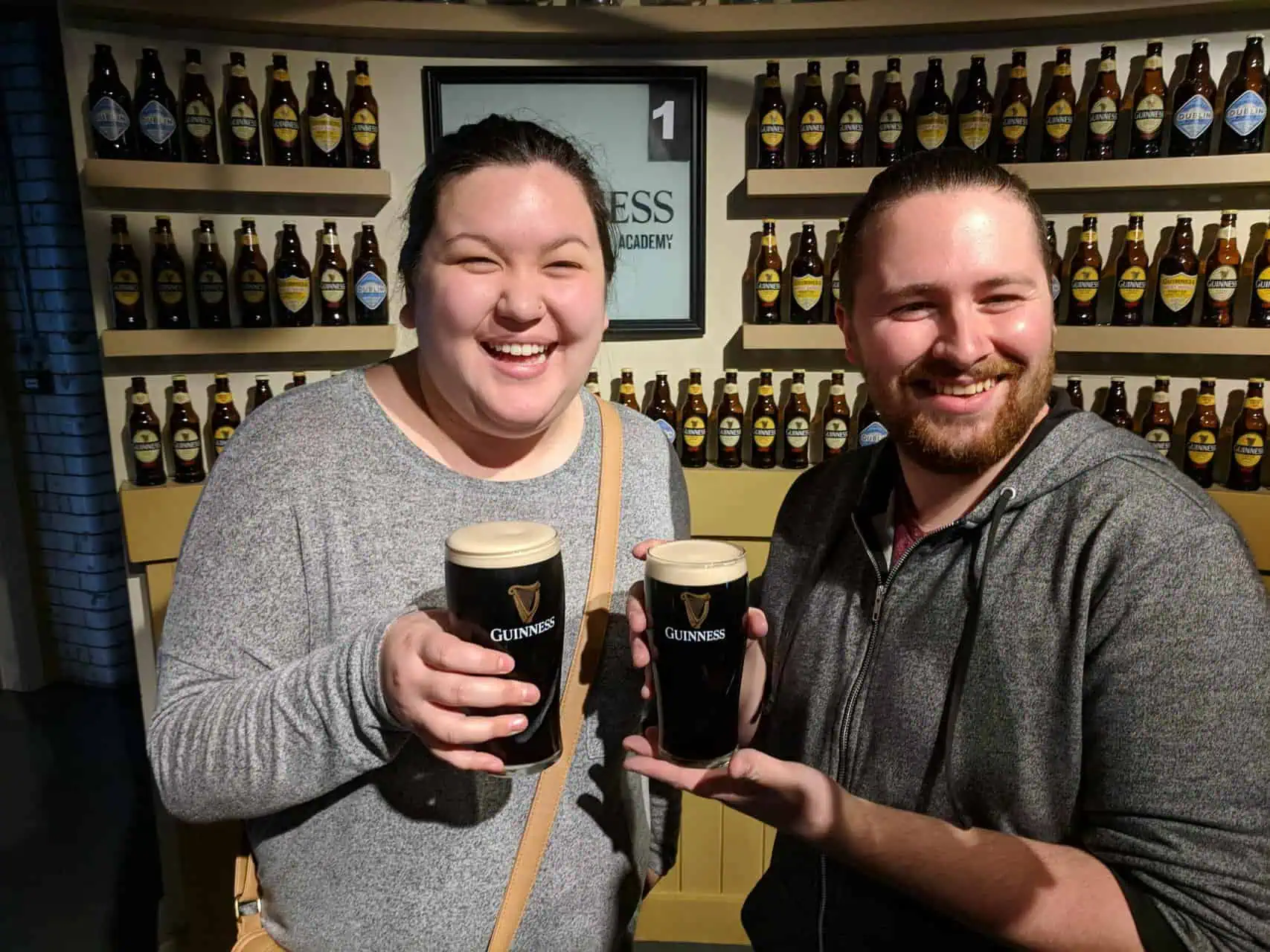 Colin and Riana holding fresh pints of Guinness at the Guinness Storehouse in Dublin, Ireland