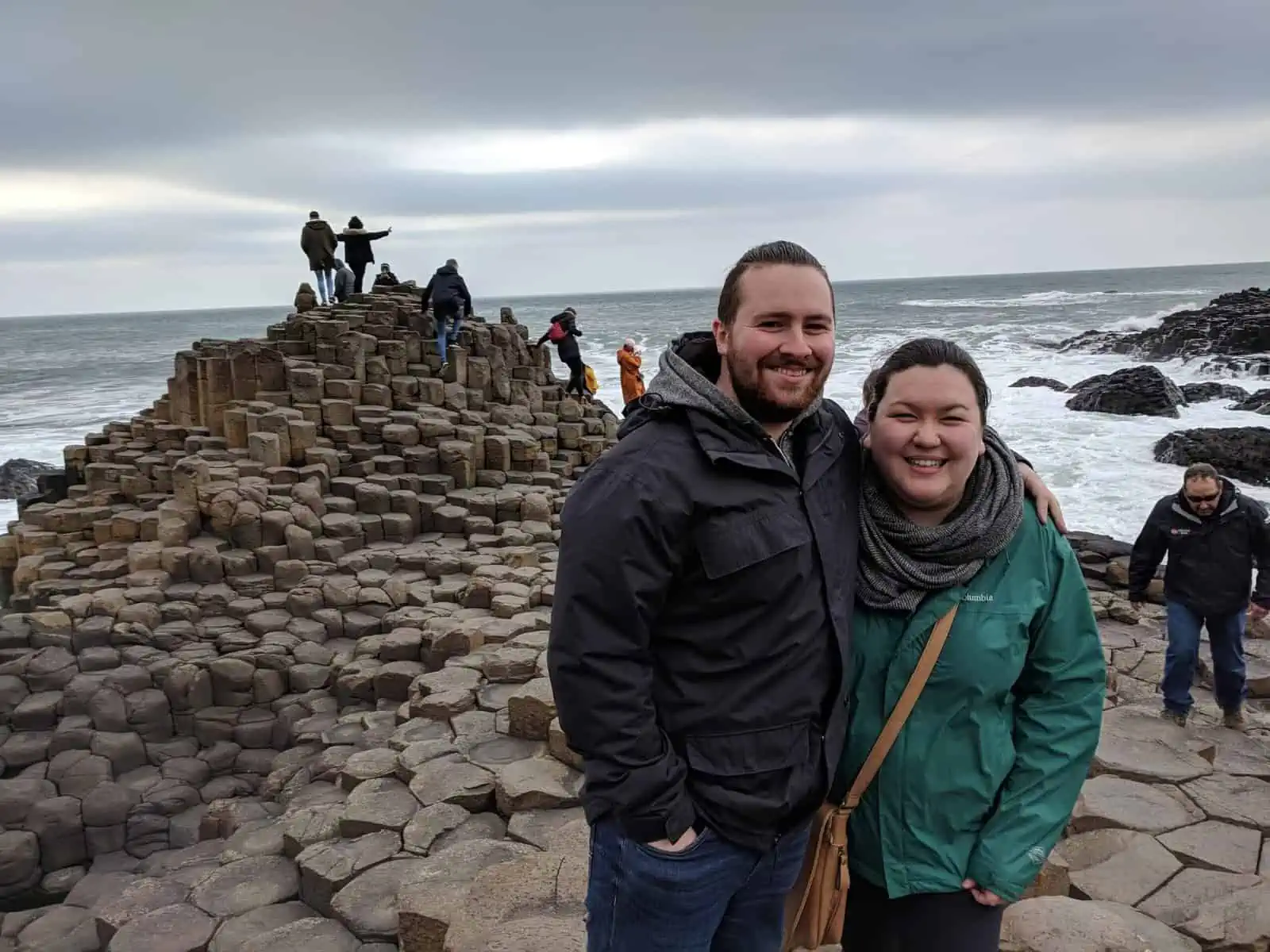 Riana and Colin on their first trip to Ireland, posing in front of Giants Causeway in rain jackets and scarves