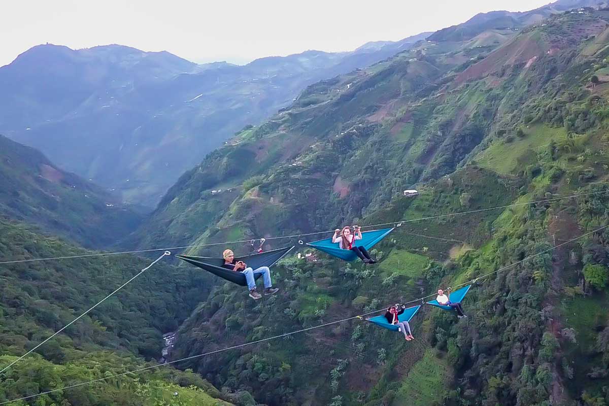 People sit high above the valley on the Dream Hammocks by Eco Adventures in Medellin