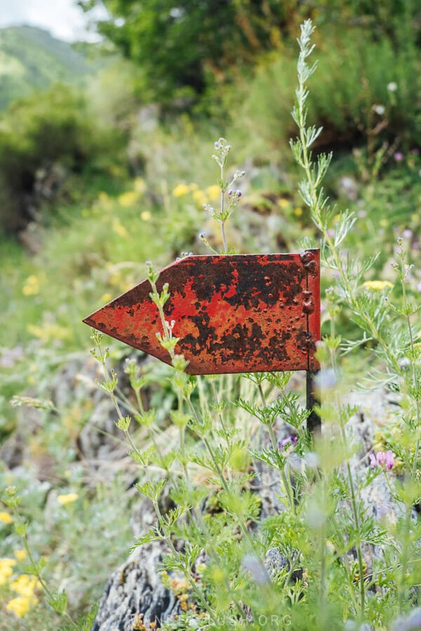 A metal flag marks the trail to Mutso Castle in Georgia.