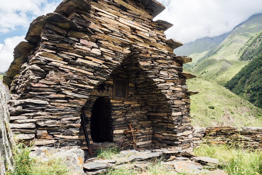 A stone Orthodox church with an arched door in the mountains of Mutso.