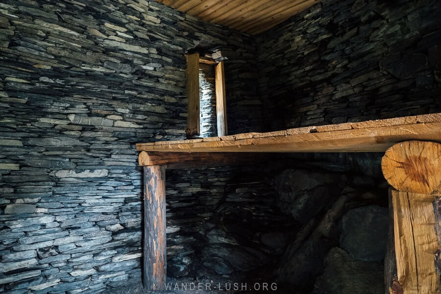 The dark interior of a Mutso tower, with wooden platforms and restored windows.