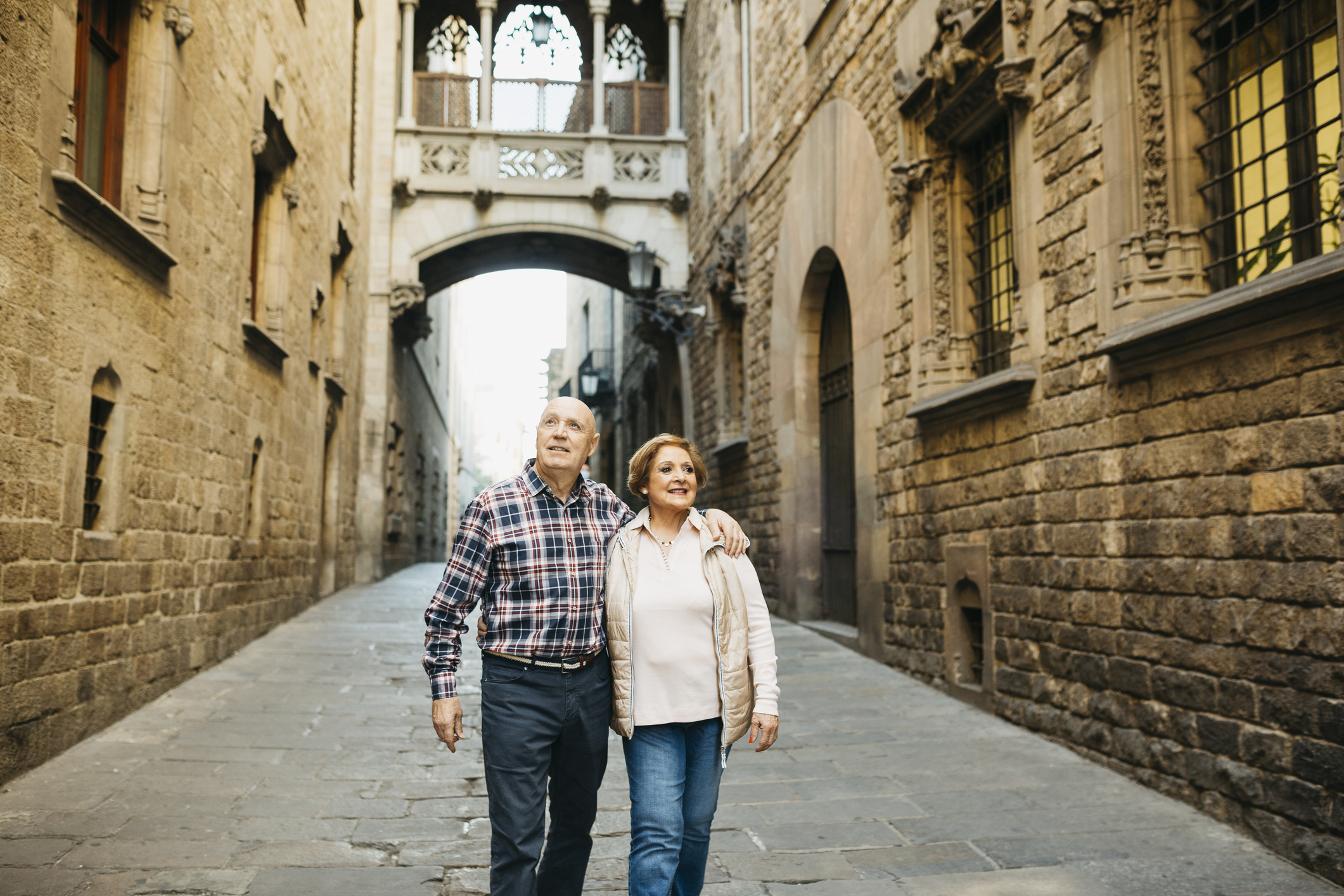 Senior couple walking around the gothic quarter of Barcelona in Spain