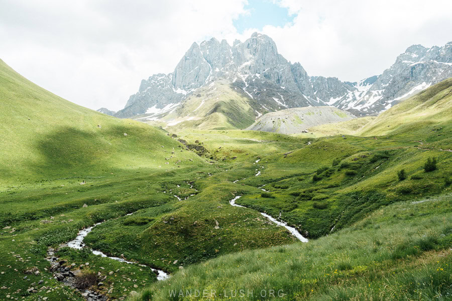 Two ribbon-like silver streams wind towards Chaukhi Massive in Georgia.