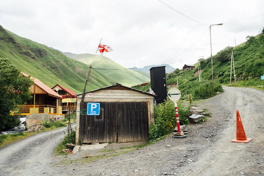 A shack with a parking sign and a road block in Juta village.