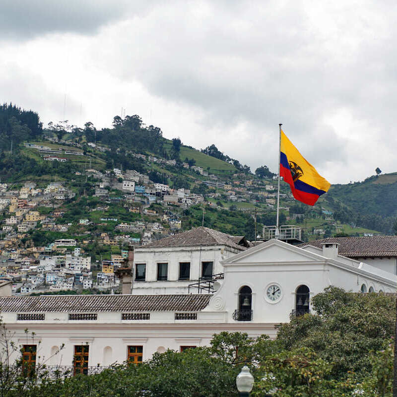 Ecuador Flag Flying Atop Public Building In Quito, Capital Of Ecuador, South America