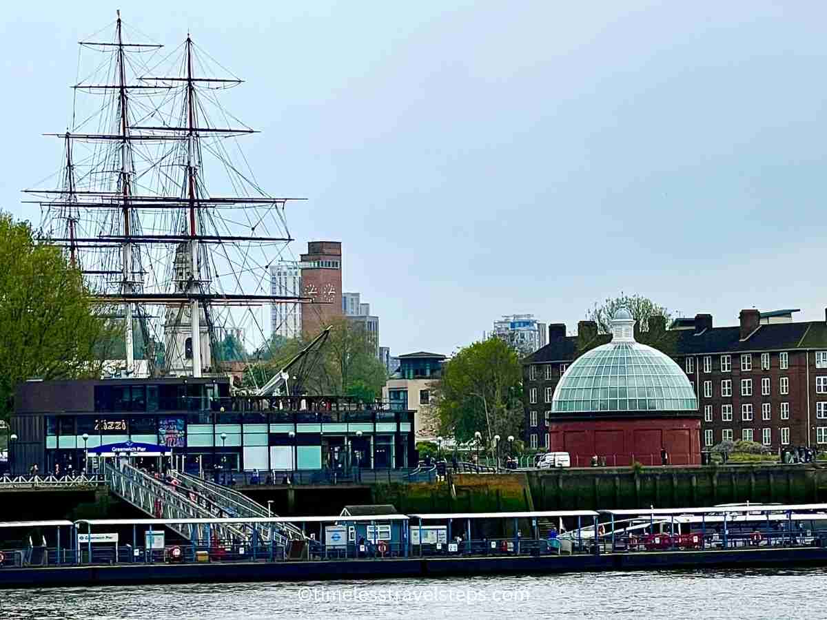 view of Cutty Sark, foot tunnel dome, and Greenwich Pier seen from Island Gardens