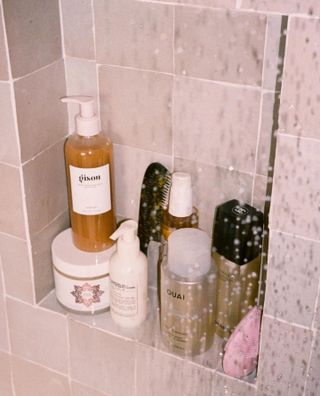 Beauty products on a shelf in the shower.