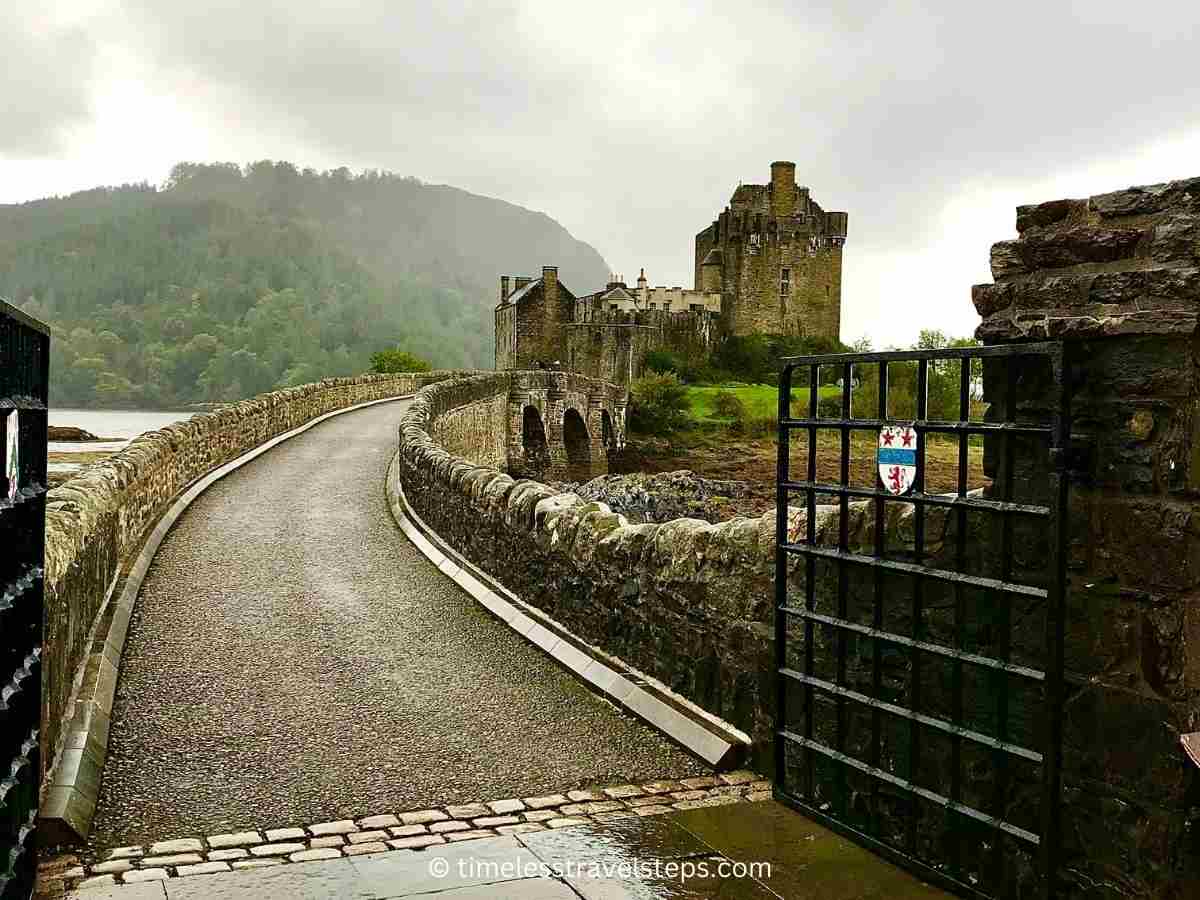 view of the entrance to Eilean Donan Castle across the stone bridge from the main gates