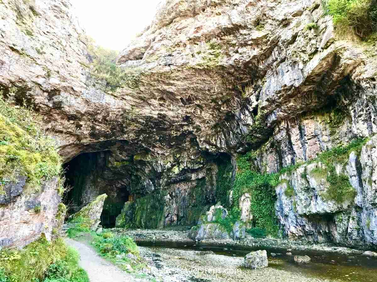 limestone rock formations showcasing intricate textures and patterns. The limestone is illuminated by natural light highlighting the rugged, weathered surfaces and the unique geological features that make the cave a fascinating natural wonder.