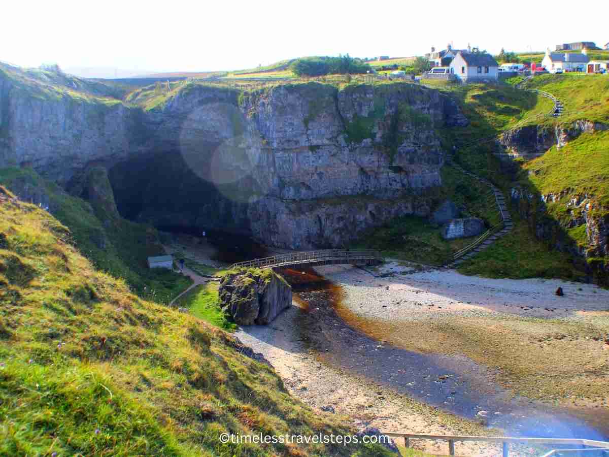 view of the wooden bridge across the water as you descend along the steep steps 