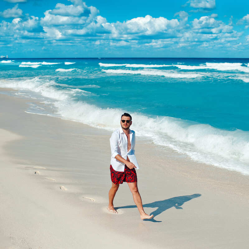 Young Male Tourist Walking The Beach In Cancun, Mexico