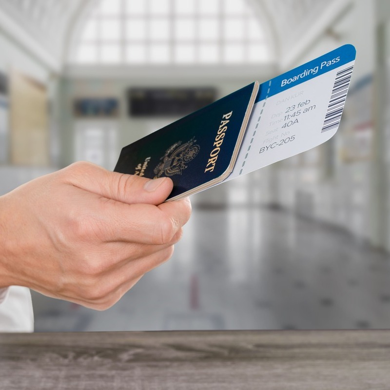 Traveler Holding Up A US Passport With A Boarding Pass, International Travel