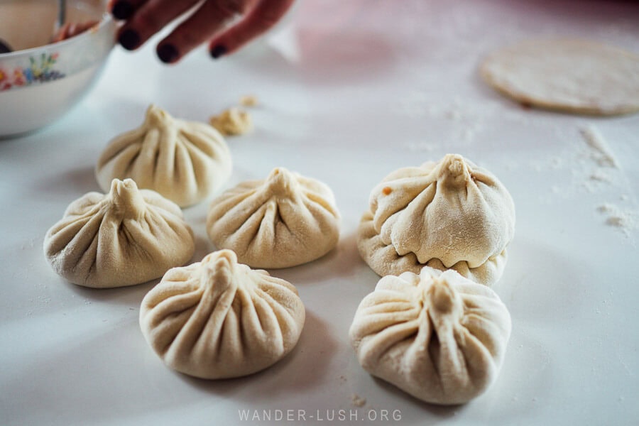 Six khinkali dumplings sitting on a bench at a homestay in Kazbegi waiting to be cooked.