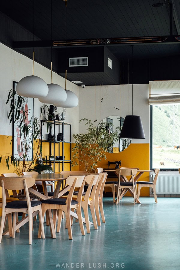 Inside a restaurant with tables set against a wall painted yellow.