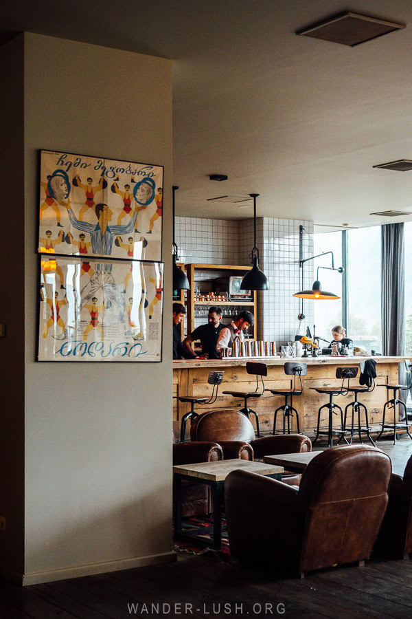 A retro poster decorates the dining lounge at Rooms Hotel in Kazbegi.