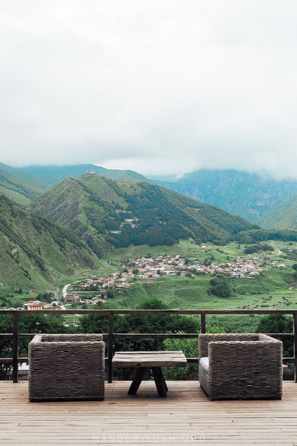 A view of Gergeti Trinity Church across the green valley in spring in Kazbegi.