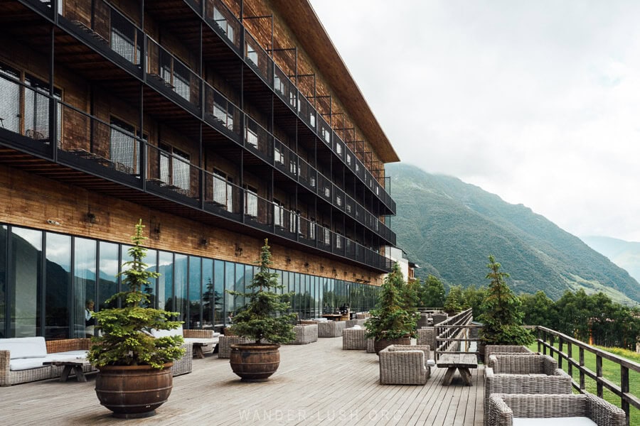 A terrace with outdoor seating overlooking the mountains at Rooms Kazbegi hotel.