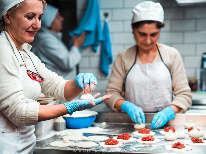 Two chefs prepare khinkali dumplings at Shemomechama restaurant.