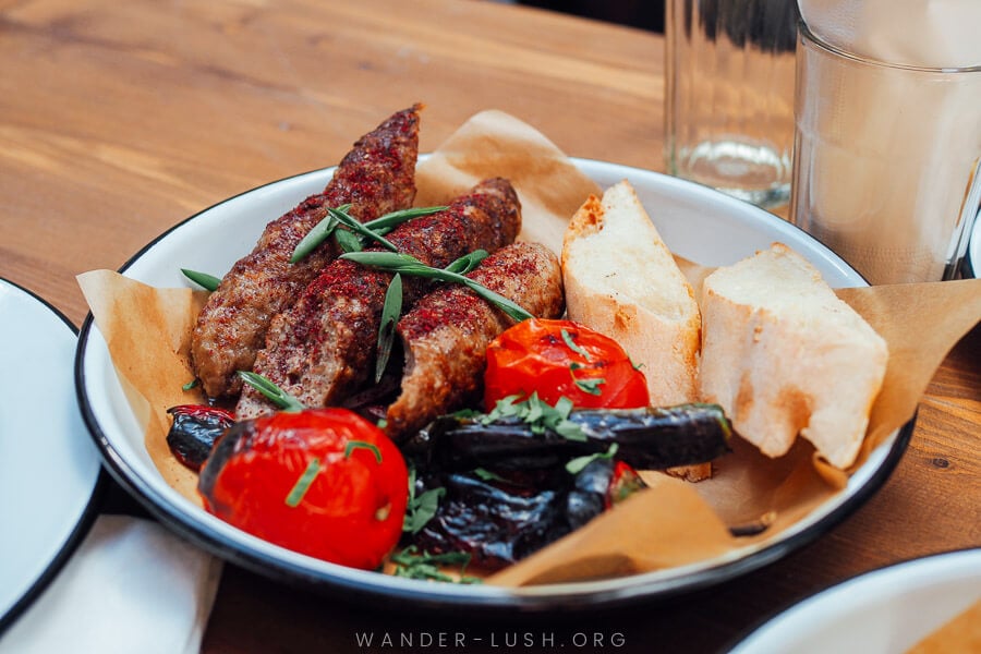 A plate of meat kebab and roasted tomatoes at Honore, best BBQ in Tbilisi.