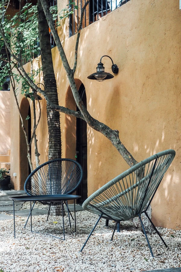 The outdoor dining area at Kaklebi, with comfy chairs set under the trees.