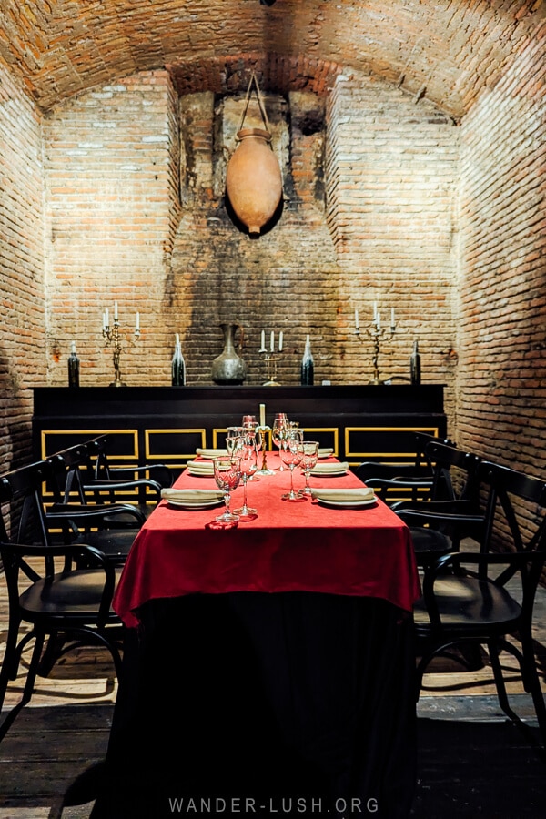 An intimate dining room at Archive Restaurant in Tbilisi, with a clay qvevri handing from the wall.