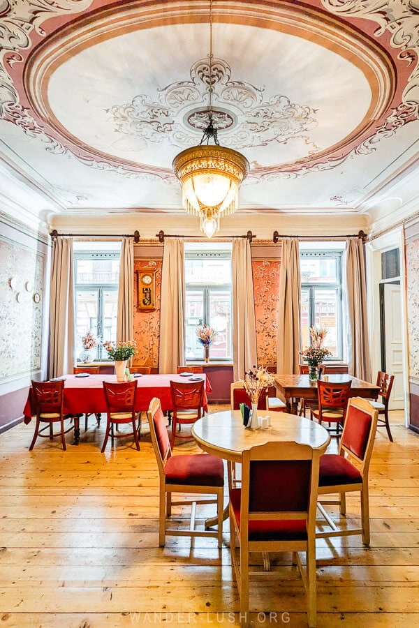 Beletage, an opulent restaurant set inside a heritage family home in Tbilisi, with a beautiful painted ceiling and a vintage chandelier.