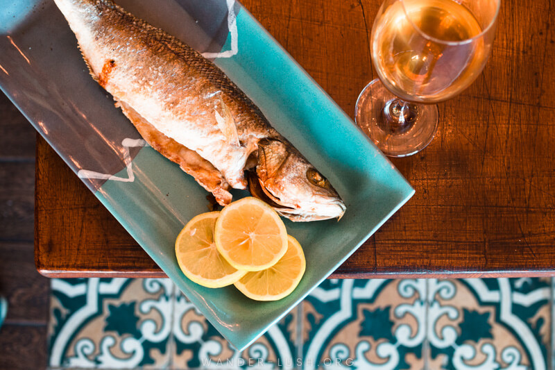 A blue plate of fish and sliced lemon at Bina N37, a unique restaurant in Tbilisi Georgia.