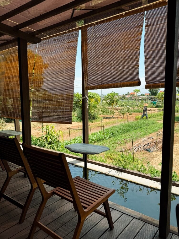 Chairs and front porch of Café Slow, overlooking the Tra Que Vegetable Village gardens and farmland near Hoi An, Vietnam.