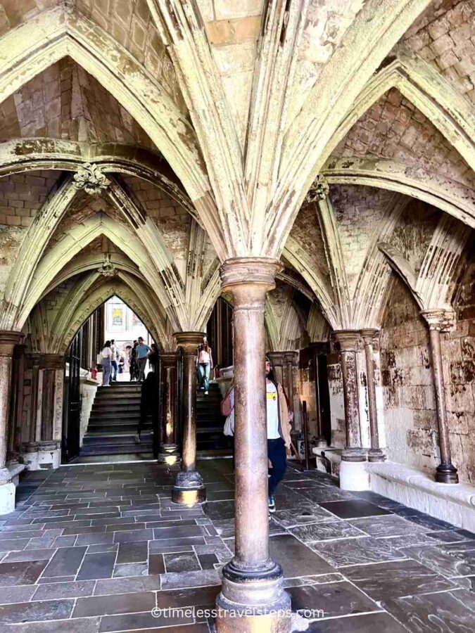 Image of the arches leading to the entrance of the Chapter House at Westminster Abbey. The Gothic arches, with their intricate stonework, create a grand and historic pathway towards the Chapter House, highlighting the architectural elegance of the medieval period.
