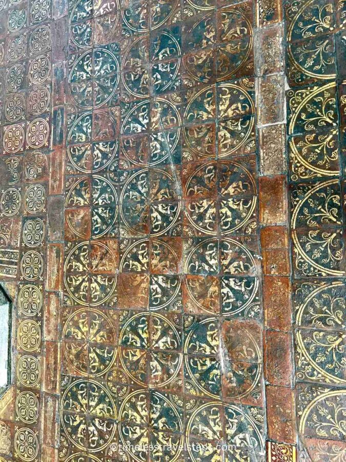 Image of the floor tiles in the Chapter House at Westminster Abbey. Though faded over time, the brightly coloured glazed tiles still showcase intricate designs, including geometric patterns and historical motifs, highlighting the exquisite craftsmanship of the medieval period.
