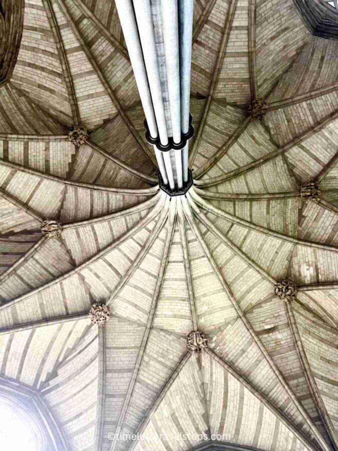 Image of the Chapter House at Westminster Abbey, showcasing the central column that soars upwards like a palm tree, supporting the vaulted ceiling. The intricate Gothic architecture and detailed stonework are highlighted, creating an awe-inspiring view.