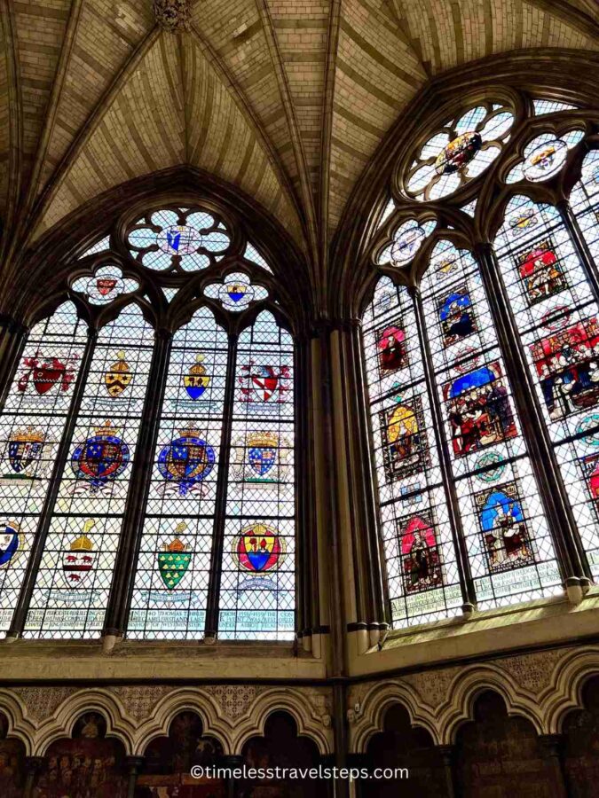 Image of the stained glass windows at the Chapter House in Westminster Abbey, featuring vibrant colours and intricate patterns. Installed after the Second World War, these windows cast beautiful light across the room and complement the historic Gothic architecture.