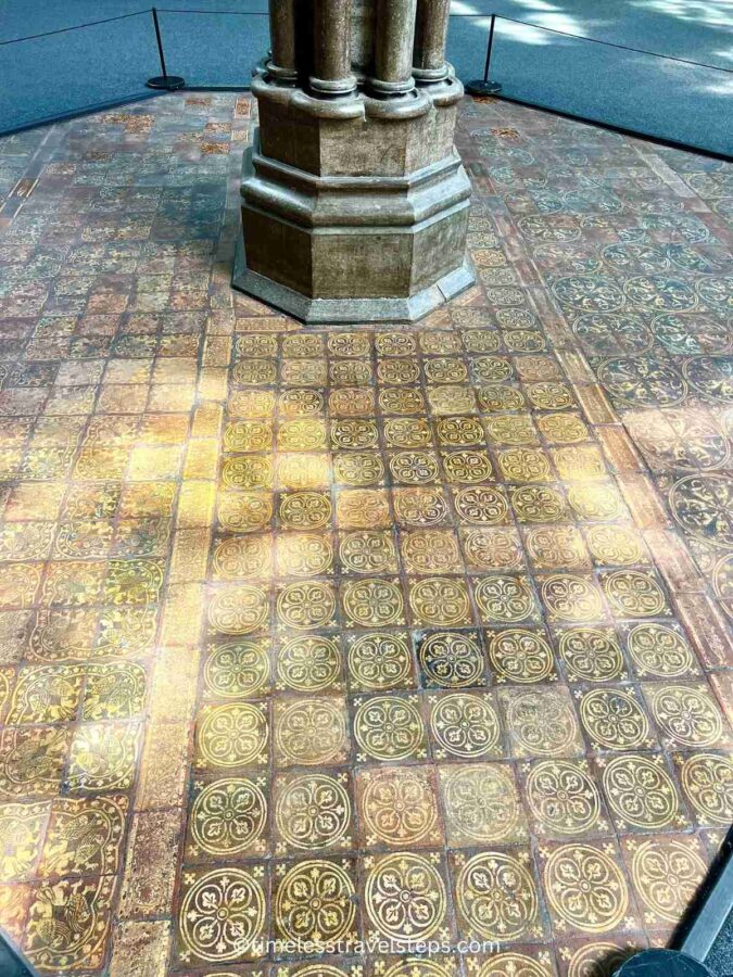 Image of the floor tiles in the Chapter House at Westminster Abbey. Though faded over time, the brightly coloured glazed tiles still showcase intricate designs, including geometric patterns and historical motifs, highlighting the exquisite craftsmanship of the medieval period.
