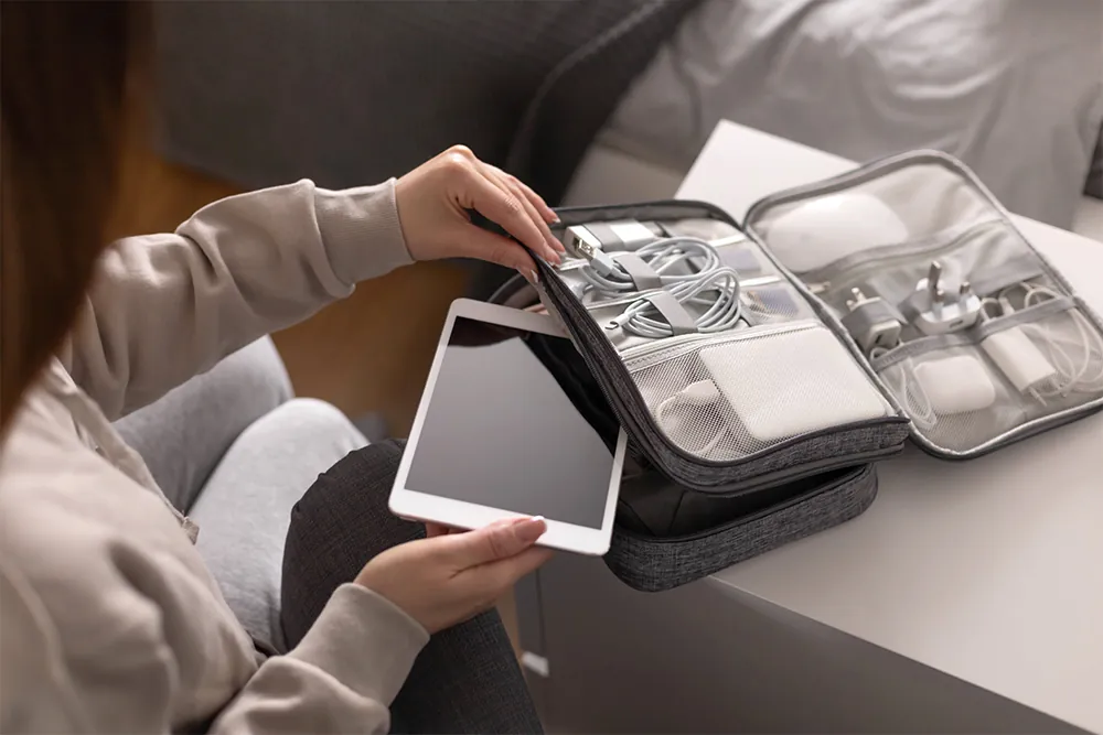 Female putting tablet pc into comfortable bag storage get ready to business trip or vacation