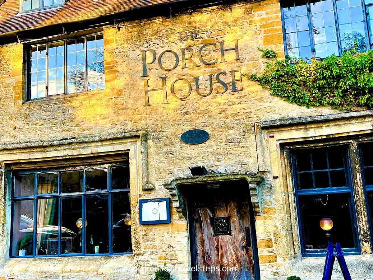 the frontal view of the historic Porch House, reputed to be the first inn in england. rustic oak door and weathered bricks | stow on the wold history